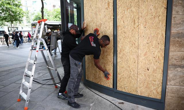 Vor dem Schließen der Wahllokale sicherten Arbeiter am Sonntag die Auslagen von Geschäften auf der Pariser Avenue des Champs-Élysées angesichts befürchteter Ausschreitungen.