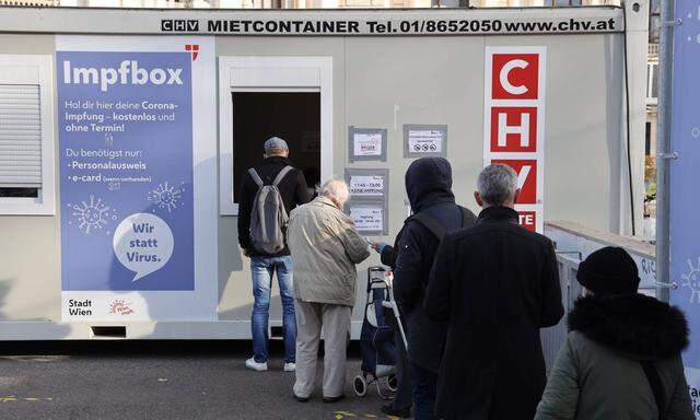 Menschen stehen Schlange vor einer Impfbox in Wien