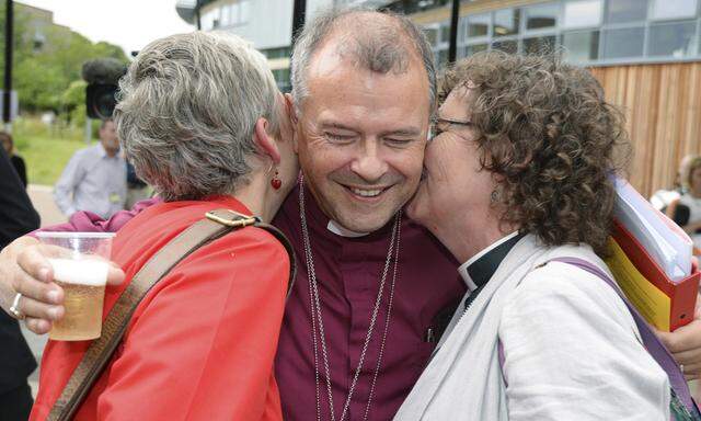 Bishop of Gloucester Michael Perham hugs female clergy members after the Synod session which approved the consecration of women bishops, in York