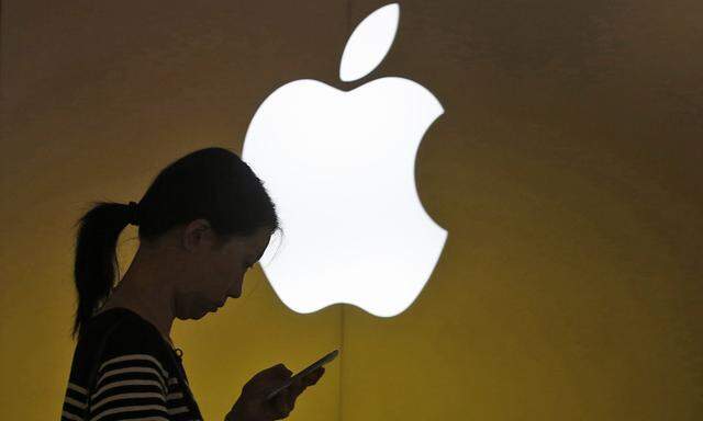 Frau mit Smartphone vor Apple-Logo