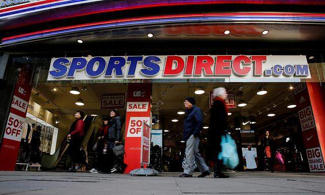FILE PHOTO: Shoppers walk past Sports Direct store on Oxford Street in London