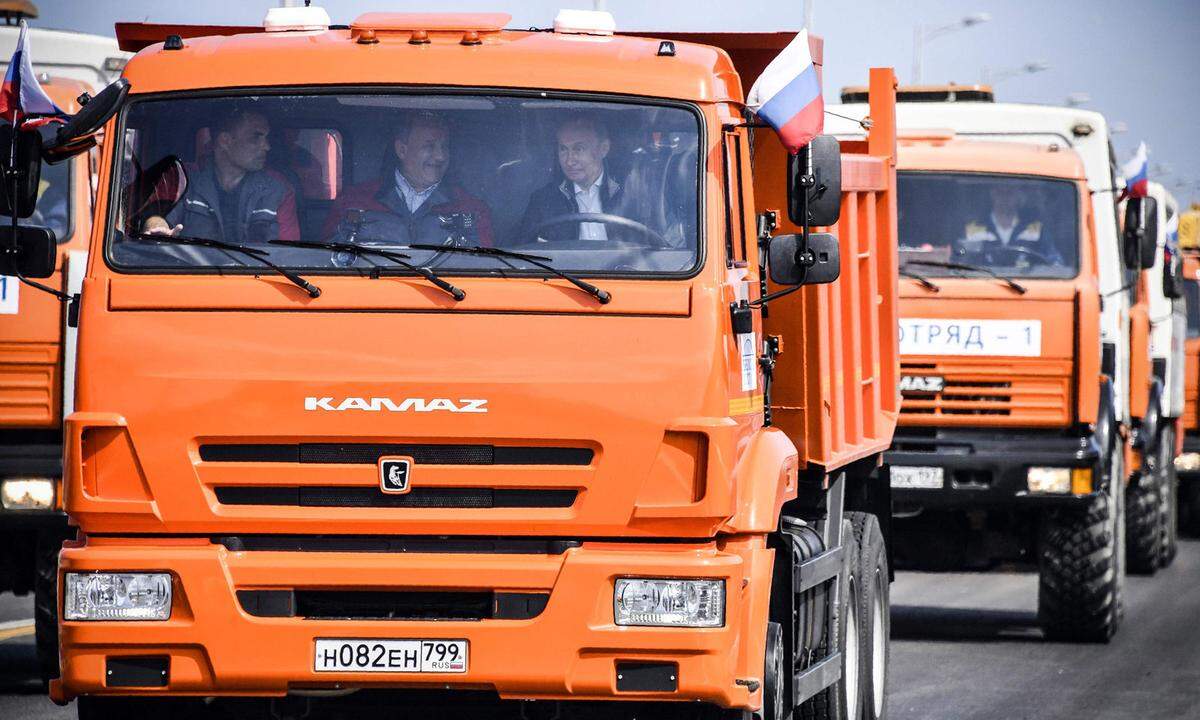 Der Staatschef fuhr mit einem orangefarbenen Transporter gefolgt von mehreren weiteren Lkw über die Brücke über der Meerenge von Kertsch. 