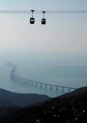 Cable cars move in front of the Hong Kong-Zhuhai-Macau bridge off Lantau island in Hong Kong