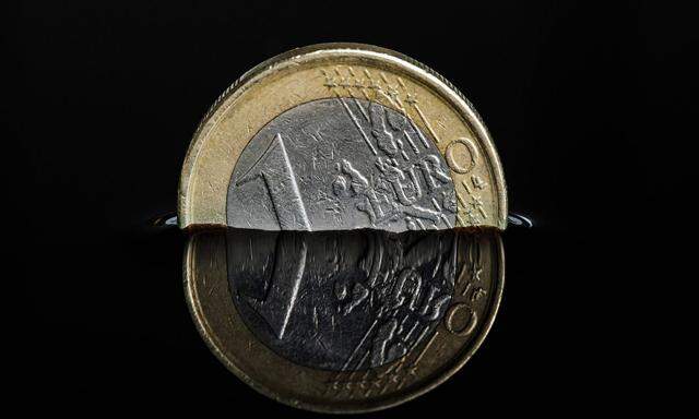 Euro-Muenze in einer dunklen Fluessigkeit Foto:xC.xHardtx/xFuturexImage