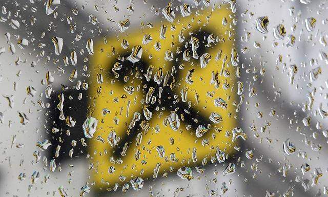 The logo of Raiffeisen bank is pictured through raindrops at a branch office in Vienna