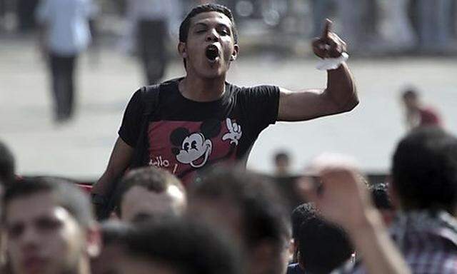 An Anti-military protester chants slogans against their military rulers after an attack on protesters