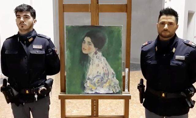 Italian police stand next to what they say is a masterpiece by Austrian artist Gustav Klimt that was stolen in 1997 and was found hidden in an outside wall of an Italian gallery, in Piazcenza