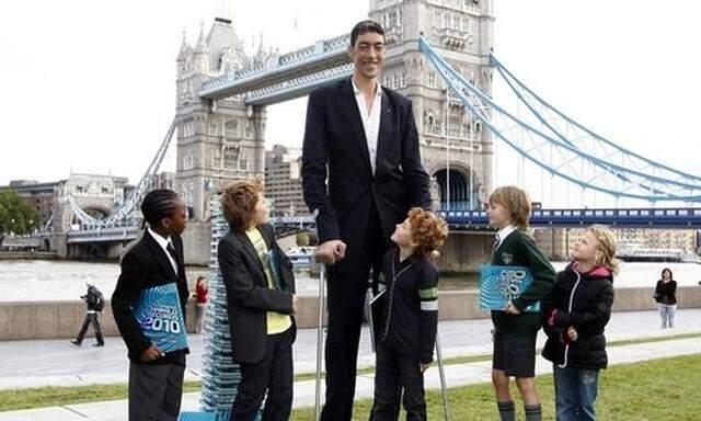 Schulkinder posieren mit dem größten Mann der Welt, dem Türken Sultan Kosen, in London.