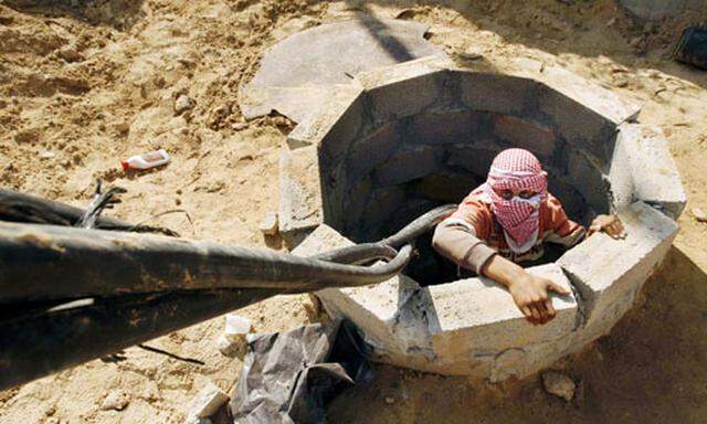 A Palestinian smuggler prepares to smuggle fuel into Gaza through a tunnel beneath the Egyptian-Gaza