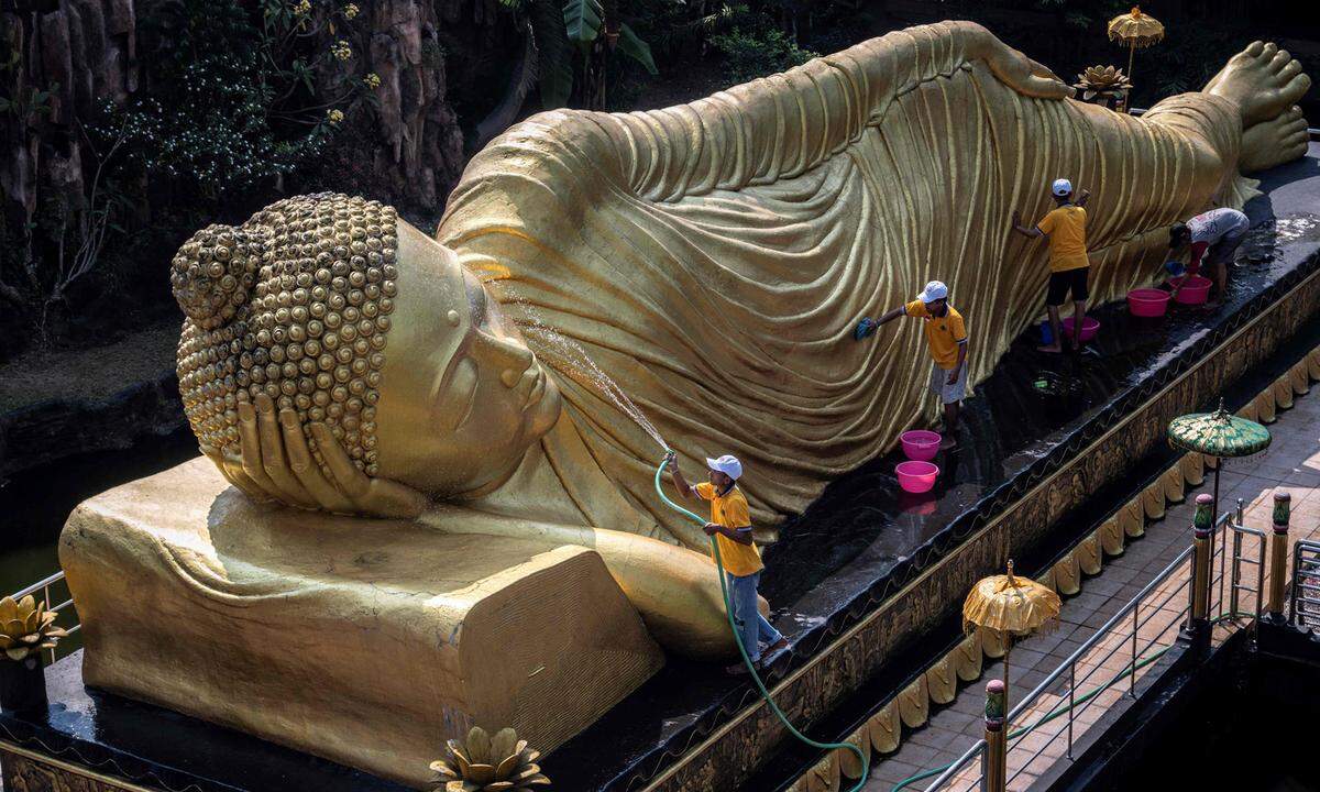 30. Mai. Arbeiter reinigen eine Buddha-Statue im Maha Vihara Mojopahit-Tempel in Mojokerto vor dem Vesak-Fest, das an die Geburt, die Erleuchtung und den Tod Buddhas erinnert.