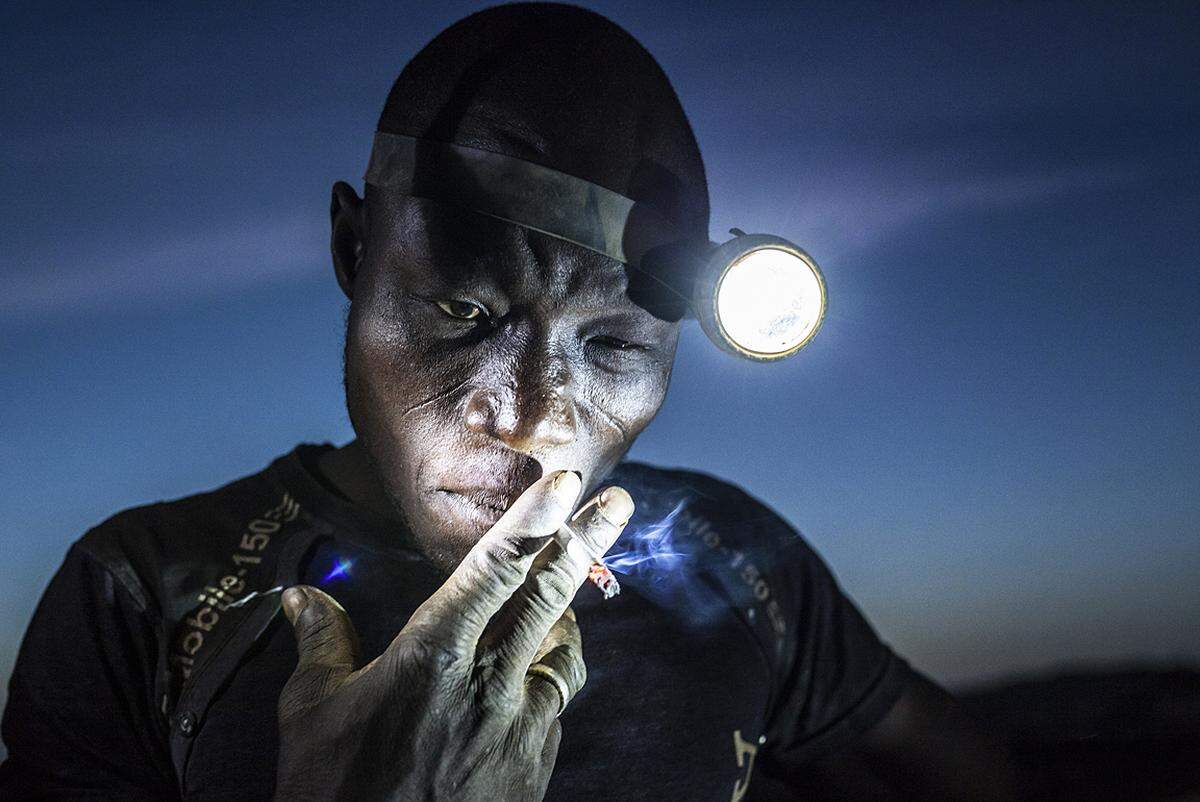 Matjaz Krivic, Slowenien, 2015, Digging the Future Ein Minenarbeiter am 20. November in Bani, Burkina Faso, bei der Rauchpause. Die Arbeiter sind extremen Bedingungen und chemischen Schadstoffen sowie Schwermetallen ausgesetzt. 