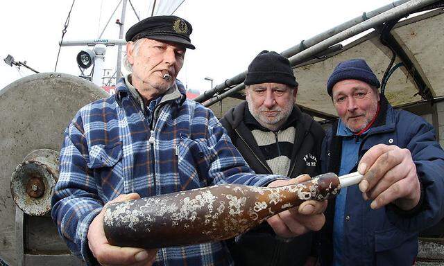 Der Berufsfischer Konrad Fischer (links) und seine Crew Klaus Matthiesen (Mitte) und Thomas Buick (rechts)haben eine Flaschenpost aus dem Jahr 1913 gefunden.