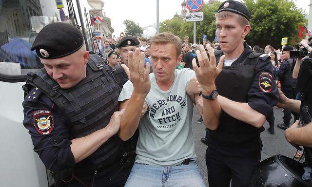 Policemen detain Russian opposition leader Navalny during a rally in support of investigative journalist Golunov in Moscow