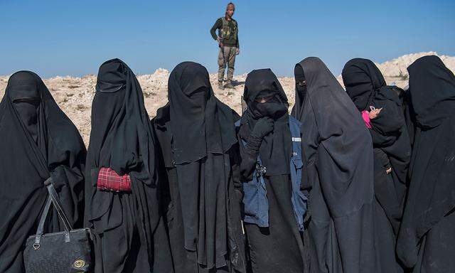 Kämpfer der Syrischen Demokratischen Kräfte bewachen gefangene Frauen von IS-Kämpfern