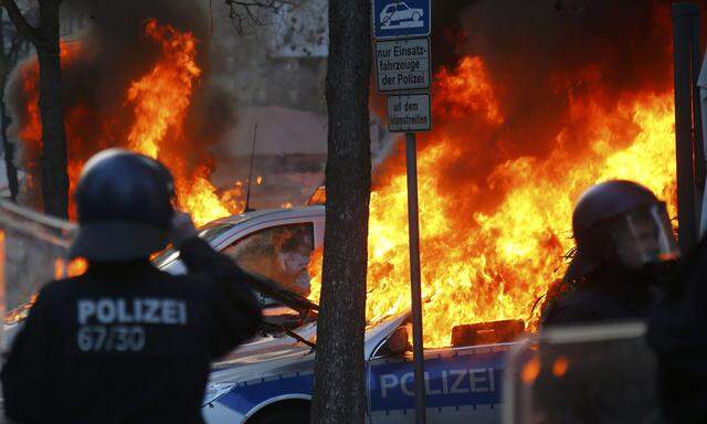 German police cars set on fire by anti-capitalist protesters burn near the new ECB headquarters in downtown Frankfurt