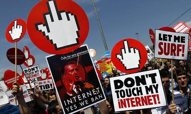 Demonstrators shout anti-government slogans as one of them carry a placard with a picture of Turkey´s PM Erdogan during a protest against internet censorship in Istanbul