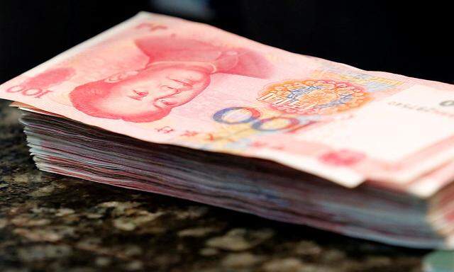 Chinese 100 yuan banknotes are seen on a counter of a branch of a commercial bank in Beijing