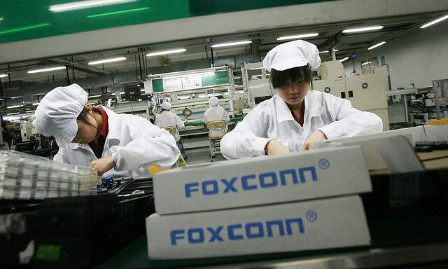 File photo of employees working inside a Foxconn factory in the township of Longhua