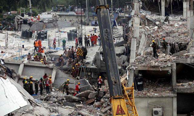 Rescue workers attempt to rescue garment workers from the rubble of the collapsed Rana Plaza building, in Savar