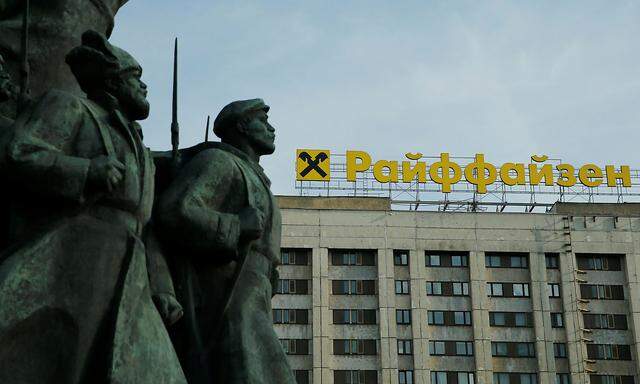 Logo of Raiffeisen Bank on top of building is seen behind fragment of statue of Soviet state founder Vladimir Moscow