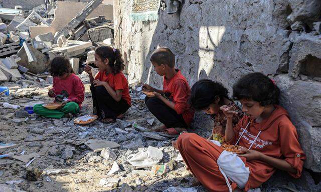 In Rafah im südlichen Gazastreifen essen Kinder in den Ruinen ihres Elternhauses. 