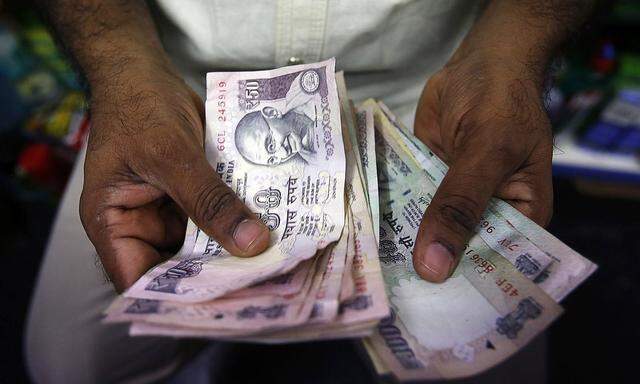 File picture shows a private money trader counting Indian Rupee currency notes at a shop in Mumbai