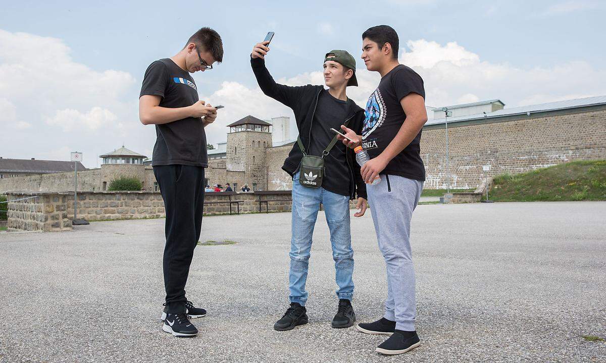 Einige der Jugendlichen machen Selfies vor dem Konzentrationslager.