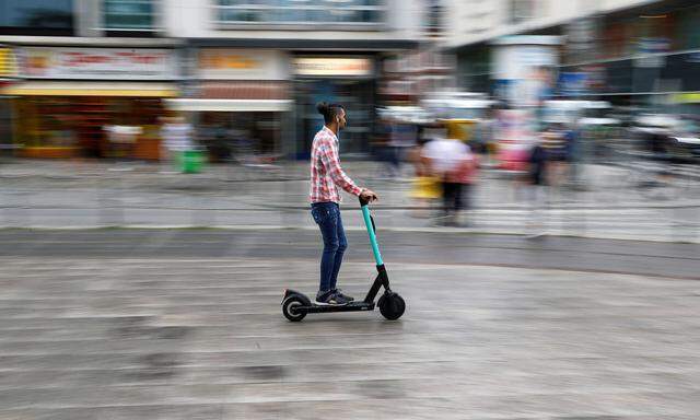 A user rides an e-scooter from provider Tier in a pedestrian area in Frankfurt