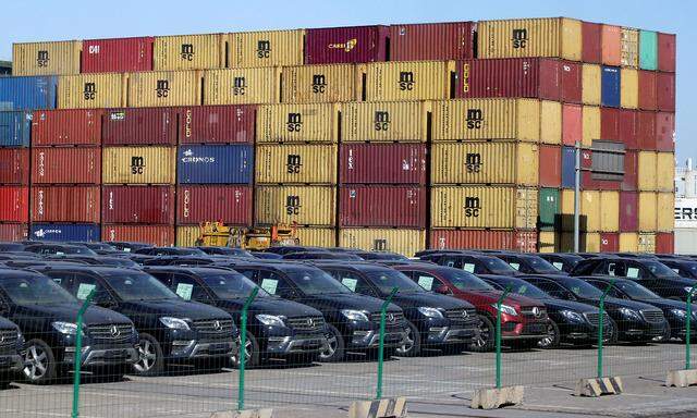 FILE PHOTO: Imported Mercedes Benz cars are seen next to containers at Tianjin Port