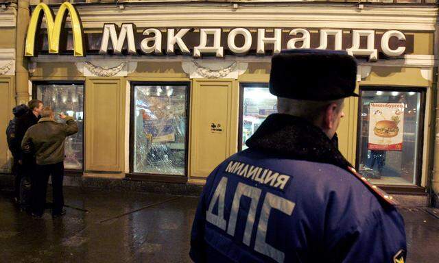 Policeman stands guard in front of a McDonald´s restaurant in St. Petersburg