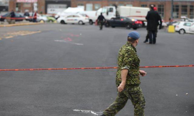A member of Canada's armed forces walks past the scene of a hit and run of two soldiers in St. Jean sur Richelieu