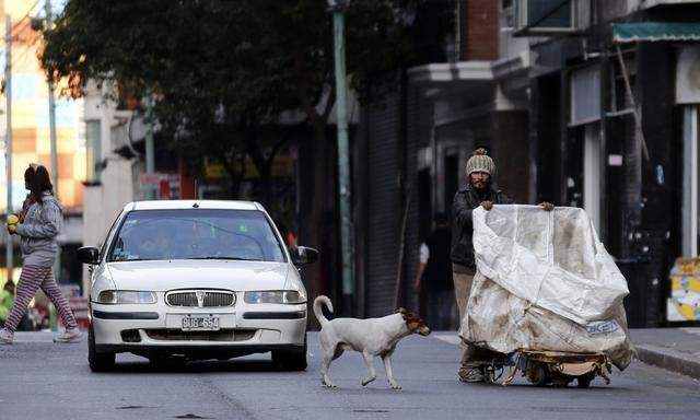 A garbage recycler pushes his cart along a street in Buenos Aires