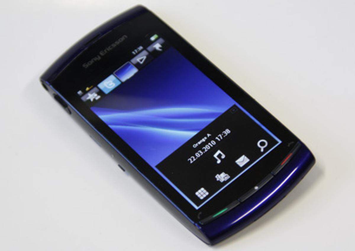 Zurück auf der Vorderseite sieht man ein vielleicht etwas gewohnteres Bild: Ein großer Touchscreen mit 3,2 Zoll Bilddiagonale und 640 x 360 Pixel beherrscht die Front. An der Unterseite deuten die drei Tasten bereits auf das Betriebssystem hin: Symbian S60 5th Edition. Der Startbildschirm ist allerdings von Sony Ericsson. Nettes Detail: der blaue "Horizont" bewegt sich je nach Ausrichtung des Geräts.