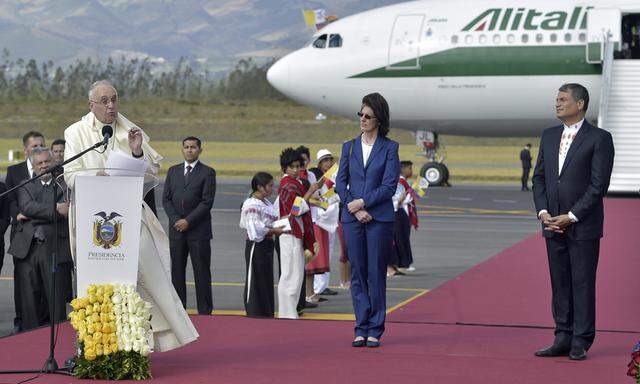 Pope Francis speaks as he is greeted by Ecuador´s President Correa after landing in Quito