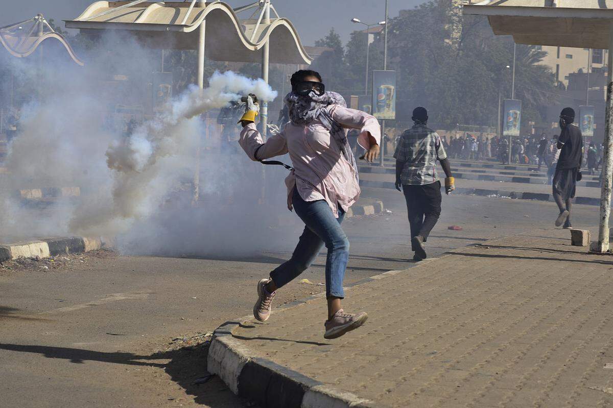 Eine Demonstrantin wirft einen Tränengas-Kanister zurück Richtung Sicherheitskräfte. Im Sudan lehnen sich Bürger gegen die herrschenden Militärs auf und verlangen eine Rückkehr zur Zivilregierung. Das Foto stammt von Faiz Abubakr Mohamed.