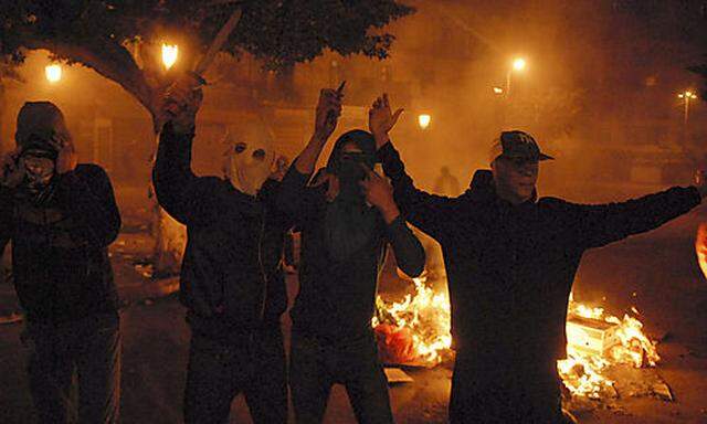 Youth react in a street of the Bab el Oued district of Algiers, during the night, Thursday Jan. 6, 20