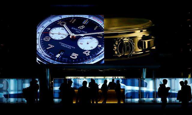 Visitors walk past the exhibition stand of Swiss watch manufacturer Breitling at the Baselworld watch and jewellery fair in Basel