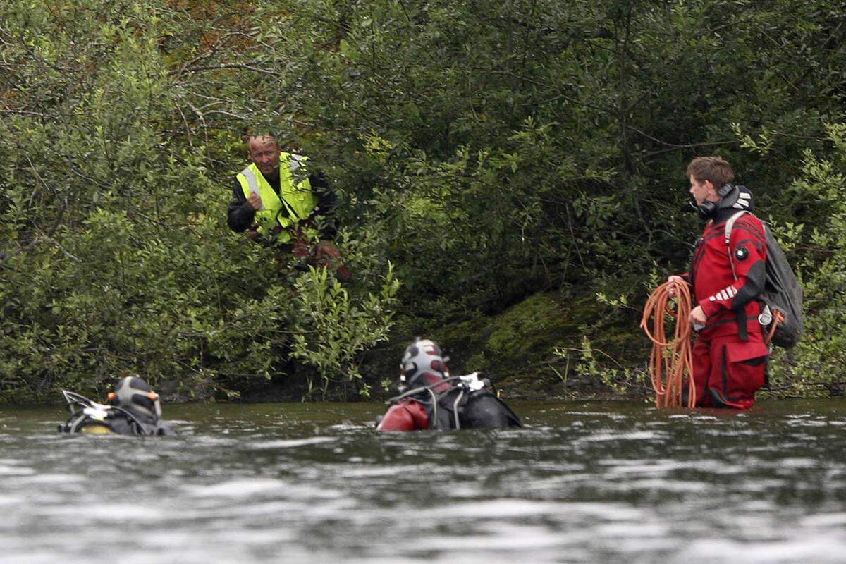 Einsatzkräfte suchen am Inselufer und im See nach Opfern. Insgesamt sterben 69 Menschen.