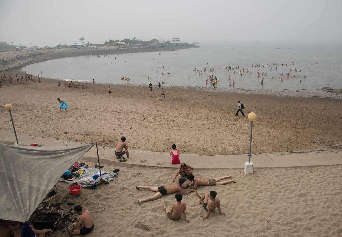 Strandparty mit Grillmuscheln auf Benzin: Im verarmten kommunistischen Nordkorea macht die Lust auf sommerliches Barbecue erfinderisch. Am Strand von Namp'o südwestlich von Pjöngjang sind die "Benzin-Muscheln" bei den Besuchern beliebt.