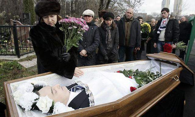 Nataliya Magnitskaya (L), mother of Sergei Magnitsky, grieves over her son 's body during his funeral at a cemetery in Moscow in this file photo