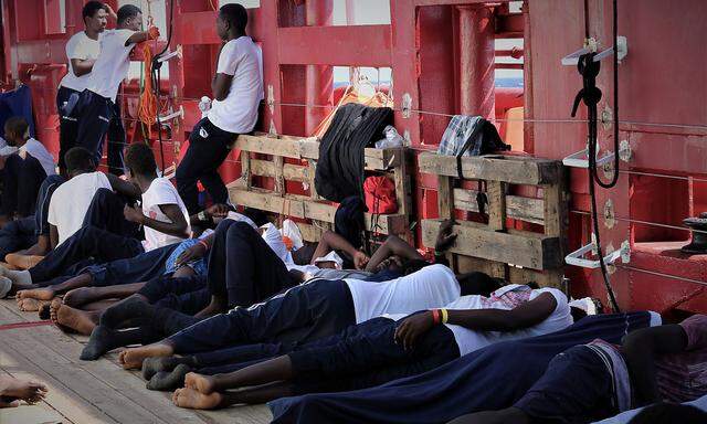 Rescued migrants rest aboard the Ocean Viking in this handout picture