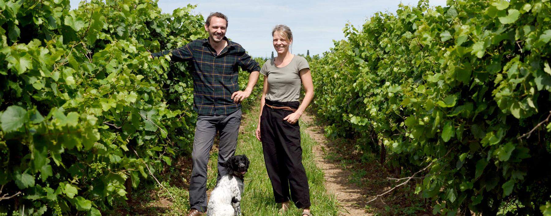 Werner und Angela Michlits (mit Hund Nala) im Weingarten, bei den wild wachsenden Reben.
