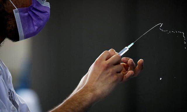 FILE PHOTO: A medical worker prepares to administer a vaccination against the coronavirus disease (COVID-19) at a temporary Clalit Healthcare Maintenance Organization (HMO) centre, at a sports hall in Netivot