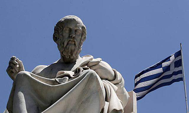 The marble statues of ancient Greek philosophers Plato, stand in front of the Athens Academy, as the 