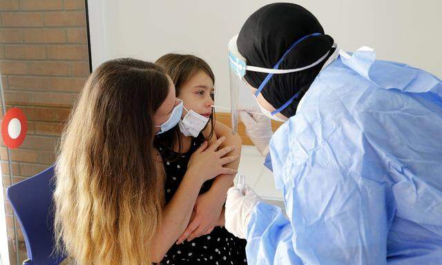 (201012) -- PETAH TIKVA, Oct. 12, 2020 -- A health worker takes a swab sample from a child for rapid coronavirus test So