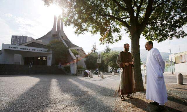 Ein katholischer Mönch und ein muslimischer Kirchgänger stehen am 31. Juli 2016 in Nizza ruhig vor Messbeginn zusammen.