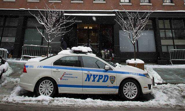 A police car sits in front of a building where  Philip Seymour Hoffman lived in New York