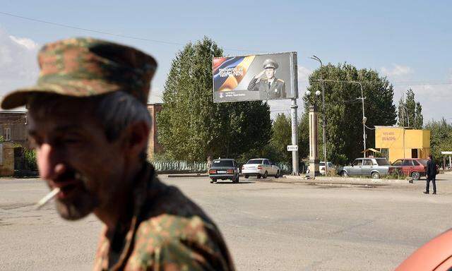 Eine Plakatwand mit dem Bild eines Soldaten und dem Slogan "Diene für das Vaterland" steht am 15. September 2022 an einer Straße in der armenischen Stadt Vardenis.