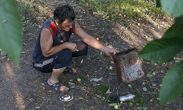 Ein Bewohner von Donetsk mit angeblichen Überresten von StreumunitionA local resident displays a dud unit of a cluster munition in Donetsk