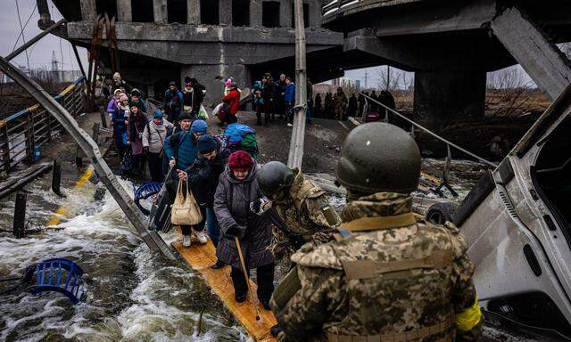 Nichts wie raus aus Irpin. Nur mit den allernötigsten Habseligkeiten machten sich die Menschen im März über eine zerstörte Brücke auf den Weg aus einer der Vorstädte Kiews.